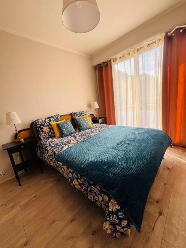 une chambre avec un lit avec une couverture bleue et une fenêtre dans l'établissement AVENUE DE CHAMPAGNE, à Épernay