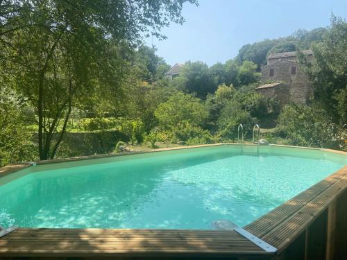 - une piscine au milieu d'une cour avec une terrasse en bois dans l'établissement Les Gîtes du Soleil Vert, à Meyrannes