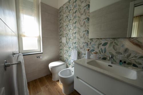 a bathroom with a white sink and a toilet at MARAF Rooms in Torre Annunziata