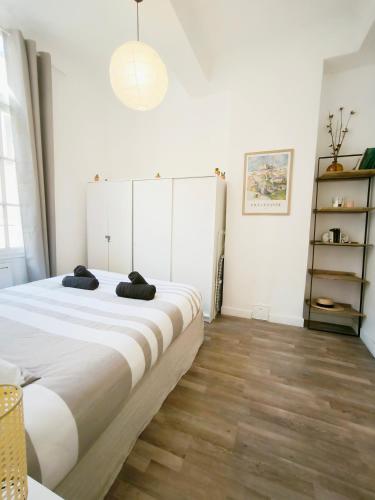 une chambre avec un grand lit avec un plancher en bois dans l'établissement Charmant T2, centre ville, lumineux, à Aix-en-Provence