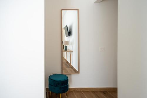 a room with a mirror and a blue stool at MARAF Rooms in Torre Annunziata