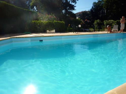 une grande piscine d'eau bleue dans une cour dans l'établissement Cannes Plage, à Cannes