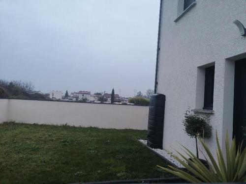 une maison blanche avec une cour à côté d'un mur blanc dans l'établissement Chez Lydie, à Tournon-sur-Rhône
