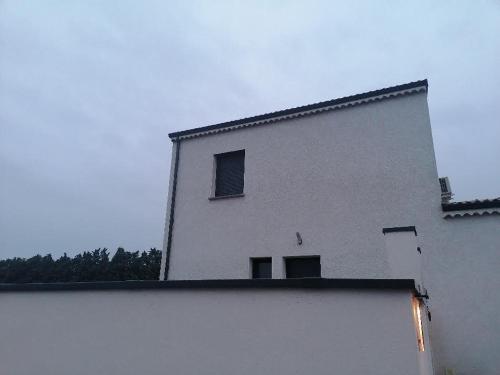 - un bâtiment blanc avec deux fenêtres au-dessus dans l'établissement Chez Lydie, à Tournon-sur-Rhône