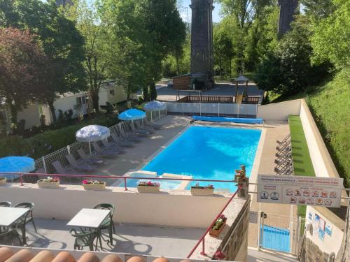 une vue aérienne d'une piscine avec chaises et parasols dans l'établissement Les rives d'Auzon, à Lavilledieu