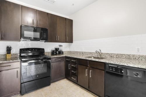 アーリントンにあるElegance & Comfort Await You in Our Aptのキッチン(ブラウンキャビネット、コンロ、電子レンジ付)