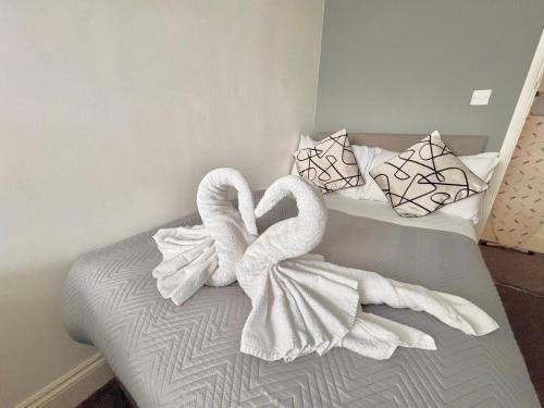 two swans wrapped in towels sitting on a bed at Contractor Group relocation accommodation Birmingham in Birmingham