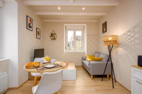 a living room with a table and a couch at Le 61-Appart'Hôtel-GregIMMO in Vieux-Charmont