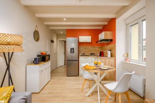 a kitchen and dining room with a table and chairs at Le 61-Appart'Hôtel-GregIMMO in Vieux-Charmont