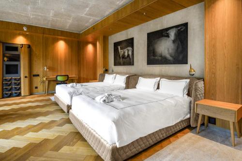 a bedroom with two beds with white sheets at Swissôtel Damian Jasna in Demanovska Dolina