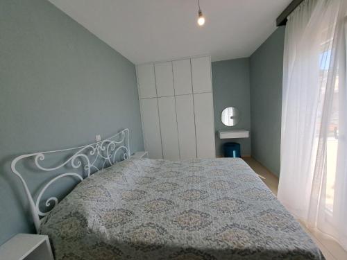a bedroom with a bed and a window at Stella Apartments in Néa Péramos