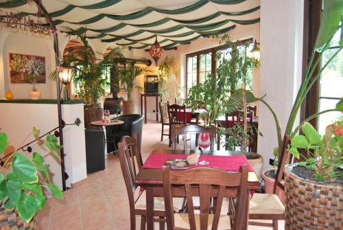 ein Esszimmer mit einem Tisch und einigen Pflanzen in der Unterkunft Hotel Obere Mühle in Bad Elster