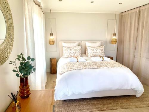 une chambre avec un grand lit blanc avec deux oreillers dans l'établissement L'instant Beaujolais 2 ou 4 personnes Logis cosy balnéo vue jardin, à Theizé