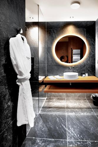 a bathroom with a sink and a mirror at Swissôtel Damian Jasna in Demanovska Dolina