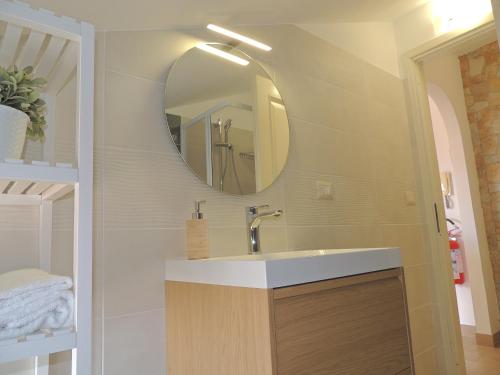 un baño con lavabo y espejo en LA SCOGLIERA - Apartment, en Stazzo