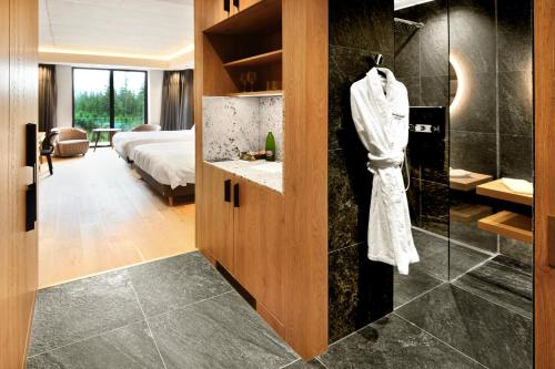 a bathroom with a shower and a bedroom at Swissôtel Damian Jasna in Demanovska Dolina