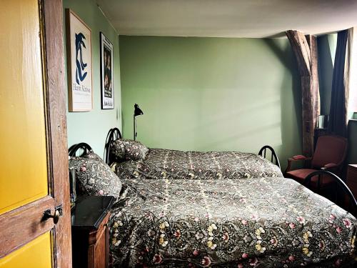 a bedroom with a bed with a comforter on it at Maison Beurdelaine in Avallon