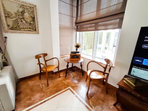 a living room with a table and chairs and a window at L'Orchidée - Suites de Luxe avec Piscine Chauffée et Vue sur le Lac de Tunis in Tunis