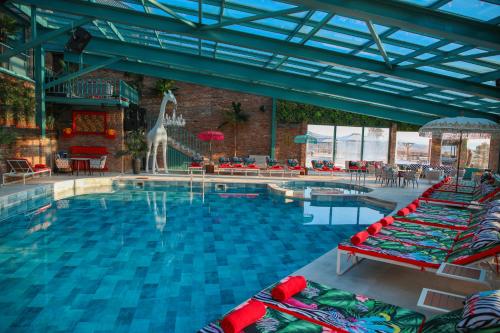 a swimming pool with chairs and a giraffe in a building at Mtserlebi Resort in K'vishkhet'i