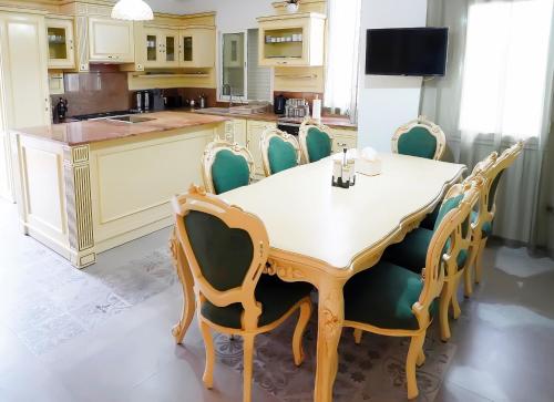 a kitchen with a wooden table and chairs at L'Orchidée - Suites de Luxe avec Piscine Chauffée et Vue sur le Lac de Tunis in Tunis