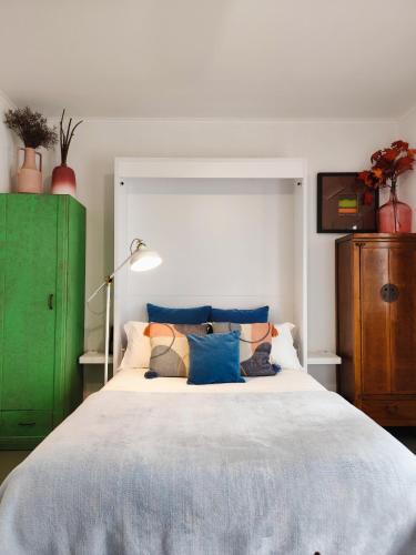 a bedroom with a large bed and a green cabinet at Stressfree Apartamento in Vila Nova de Milfontes