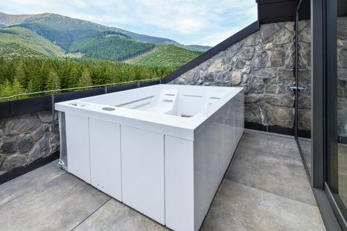 a white bathroom with a view of mountains at Swissôtel Damian Jasna in Demanovska Dolina