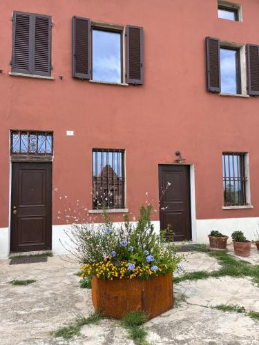 a building with doors and a flower pot in front of it at Cascina Mima - Monferrato in Quargnento