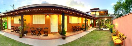 a house with a deck with a table and chairs at XIQUE XIQUE ITAUNAS HOSPEDARIA in Itaúnas