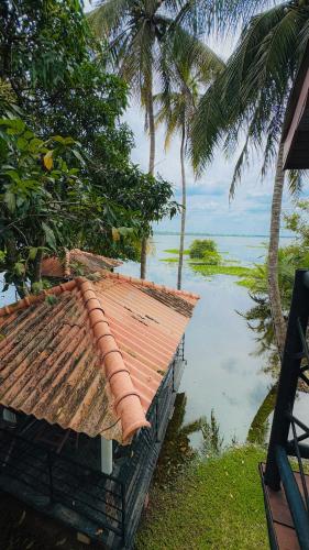 a roof of a house next to a body of water at Hotel Milenium in Kurundankulama