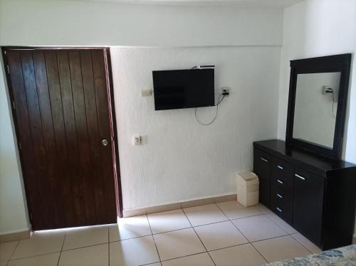 a room with a television and a door and a mirror at Habitación en Condominio frente al mar Nuevo Vallarta in Nuevo Vallarta 