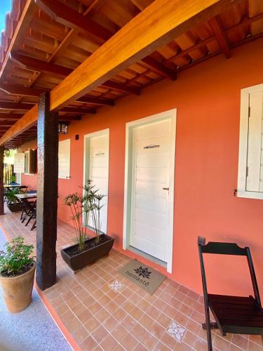 a house with an orange wall and a patio at XIQUE XIQUE ITAUNAS HOSPEDARIA in Itaúnas