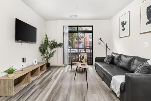 a living room with a black couch and a tv at Spacious Comfort Near Downtown Hotspots in Arlington