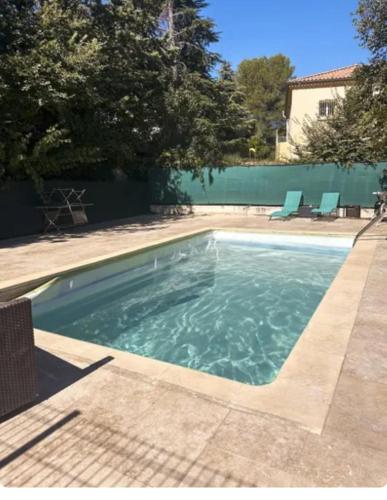 - une piscine d'eau dans une cour dans l'établissement Le clos d'Aix Célony studio 9 parking et piscine Clim, à Aix-en-Provence