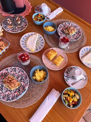 a wooden table with plates of food on it at XIQUE XIQUE ITAUNAS HOSPEDARIA in Itaúnas