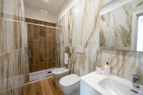 a bathroom with a toilet and a sink and a shower at MARAF Rooms in Torre Annunziata