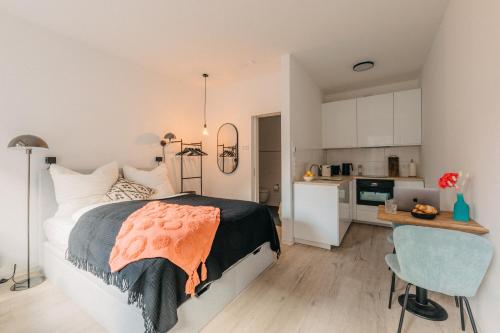 a bedroom with a bed and a desk and a kitchen at BHH Living Apartments - Zentrale Lage, ruhige Nächte, perfekter Komfort in Düsseldorf