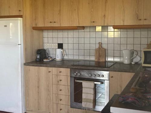 a kitchen with wooden cabinets and a stove top oven at Villa Batsheva in Roumelí