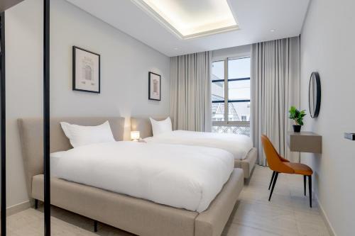 a hotel room with two beds and a chair at أكاريم أفينيوز Akareem Avenues in Riyadh