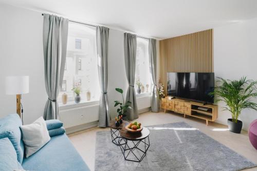 a living room with a blue couch and a tv at Kaßberg Domizil in Chemnitz