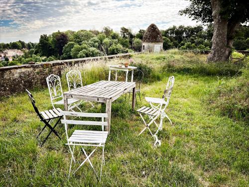 a wooden table and chairs in a field at Maison Beurdelaine in Avallon