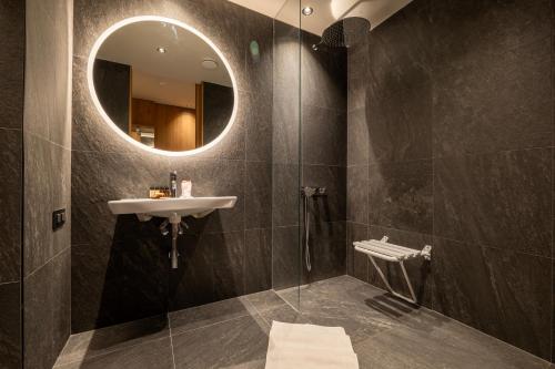 a bathroom with a sink and a mirror at Swissôtel Damian Jasna in Demanovska Dolina