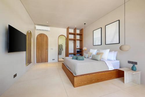 a bedroom with a large bed and a flat screen tv at 2 Bedroom Entire Place Villa Harmony Uluwatu Bingin in Uluwatu