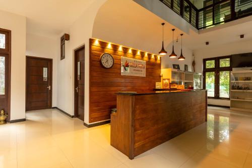 a kitchen with a counter with a clock on the wall at Hotel Bella Vista in Anuradhapura