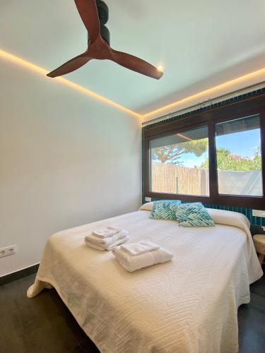 a bedroom with a bed with a ceiling fan at Novoecosuites, descansa en el lugar de tus sueños in Chiclana de la Frontera