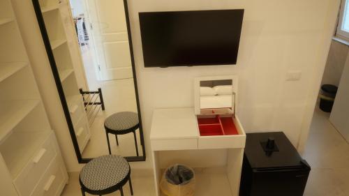 a small room with two chairs and a tv on the wall at Il Vicoletto B&B in Cirò Marina
