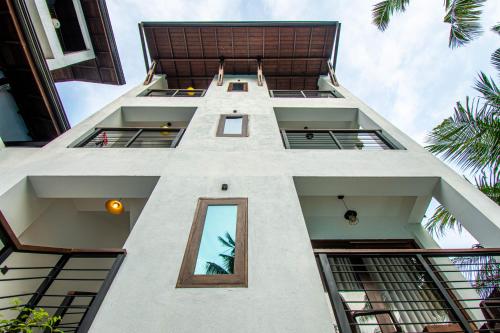 a tall white building with windows and palm trees at Hotel Bella Vista in Anuradhapura