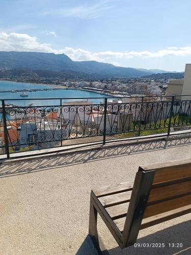 a bench sitting on a balcony with a view of the water at Seaside Breeze Apartment in Sitia