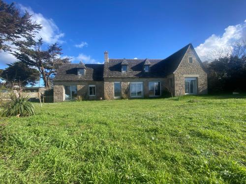une maison avec une grande pelouse devant elle dans l'établissement Villa Les Pieds dans l'Eau, à Santec