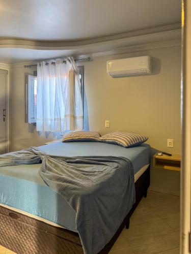 a bed in a room with a window at Casa familiar até 10 pessoas com banheira in Gramado