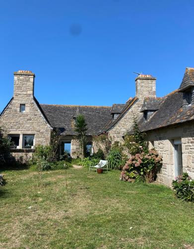 Deux maisons en pierre avec une cour devant elles dans l'établissement Villa Les Pieds dans l'Eau, à Santec